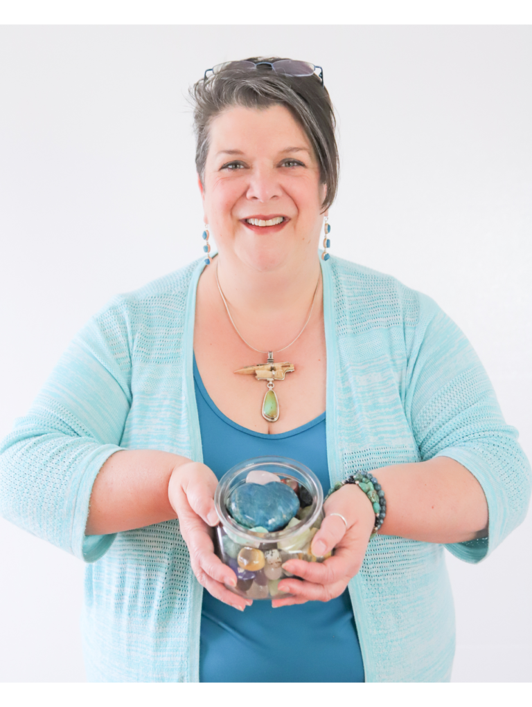 An Image of Yvette LeFlore from Healing with Yvette holding crystals with a blue top and white background.